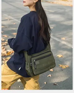 Dettaglio della borsa a tracolla verde oliva resistente all'acqua con tasche multiple