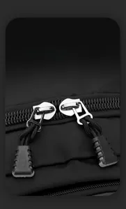 Macro shot of smooth metal double zippers and textured nylon fabric on black backpack