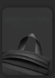 Close-up of business backpack handle with embossed leather detail and nylon webbing
