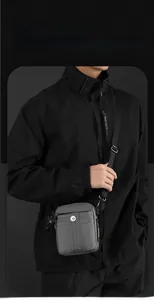 Detail of dark grey men's rectangular crossbody bag with adjustable wide nylon strap