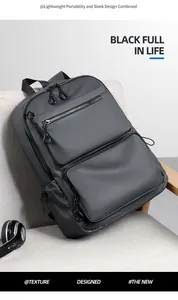 Detail of dark grey waterproof business backpack with large front zipper pockets on a chair
