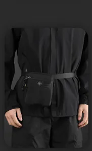 Detail of black tactical waist bag featuring water-resistant nylon and metal logo emblem