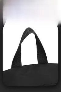 Close-up of durable woven top handle and premium black nylon fabric on the backpack