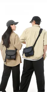 Detail of durable nylon crossbody bags in grey and navy blue with buckle closure
