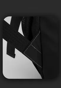 Detail view of reinforced triangular stitching and breathable mesh on a black backpack