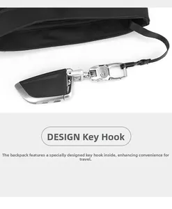 Detail of the internal key hook and retractable lanyard inside the black crossbody bag