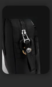 Macro detail of high-density nylon fabric and smooth silver metal zipper on men's crossbody bag