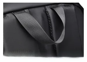 Close-up of durable reinforced handle and high-density nylon fabric on black backpack