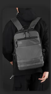 Rear view of grey waterproof laptop backpack with wide straps on a model