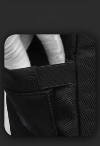Detail of the elastic side pocket on a black water-resistant commuter laptop backpack