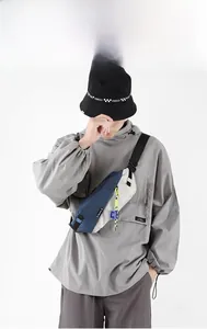 Detail view of water-resistant contrast chest bag with adjustable strap and logo label