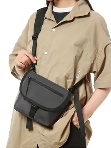 Close-up of dark grey messenger bag with adjustable strap and buckle closure detail