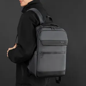 Sleek business commuter backpack in dark grey waterproof fabric worn by male model