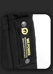 Detail of durable black fabric on shoulder bag with logo patch and vintage metal buttons