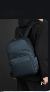 Detail view of a navy blue business backpack with smooth fabric and layered zipper design