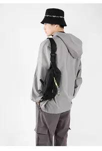 Detail of black sporty crossbody bag featuring vibrant green zippers and durable nylon fabric