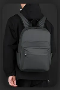 Rear view of minimalist black waterproof backpack with front pocket on a male model