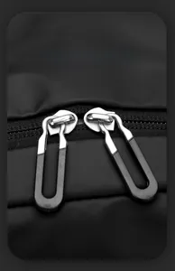 Detail of smooth double metal zippers with ergonomic non-slip pulls on a black backpack