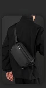 Détail du sac bandoulière noir imperméable avec sangle ajustable et logo de la marque