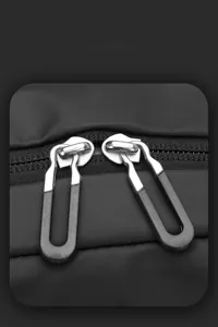 Detail of premium double metal zippers with black non-slip pulls on a business backpack