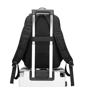 Black business laptop backpack with luggage strap mounted on a white suitcase handle