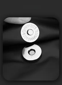 Detailed macro view of high-quality silver magnetic metal buckle on a black backpack