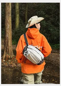 Outdoor-Umhängetasche in Off-White mit schwarzer Netztasche auf einer Jacke