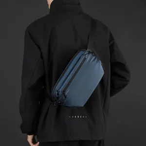 Sac bandoulière bleu marine imperméable pour homme porté par un mannequin en extérieur