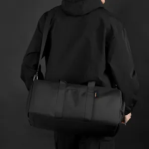 Bolsa de fitness cilíndrica negra de gran capacidad con correa de hombro en estudio