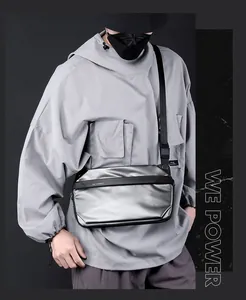 Détail du sac bandoulière techwear argenté avec sangle réglable en tissu noir