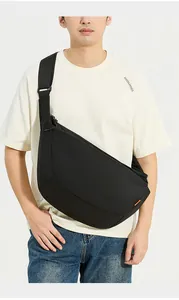 Dettaglio di una grande borsa a tracolla nera a mezzaluna con cinghia in nylon regolabile