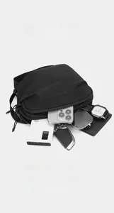 Vue détaillée du sac bandoulière noir en nylon avec rangements pour objets quotidiens