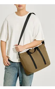 Detalle de bolso grande color caqui con asas de nailon negro reforzadas para viaje