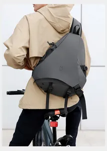 Dettaglio borsa a tracolla tattica grigio scuro con tessuto impermeabile e forma asimmetrica