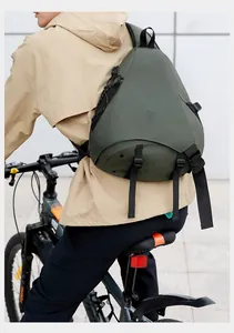 Dettaglio della borsa a tracolla impermeabile verde oliva indossata in bicicletta