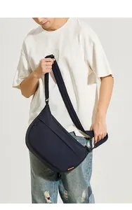 Détail du sac bandoulière en nylon bleu marine avec fermeture éclair et logo