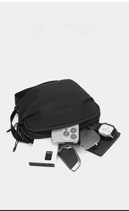 Vue macro du sac bandoulière en nylon noir montrant sa grande capacité de rangement