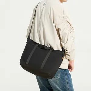 Bolso tote minimalista de nailon negro con correa ancha y detalle de mosquetón naranja