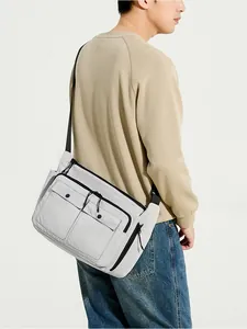 Detailed view of light gray nylon crossbody bag with dual flap pockets and black zippers