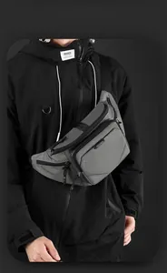 Detail view of water-resistant gray cross-body bag featuring multiple zip compartments