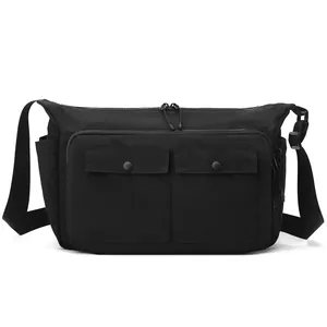 Black minimalist messenger bag with two front snap pockets and adjustable strap