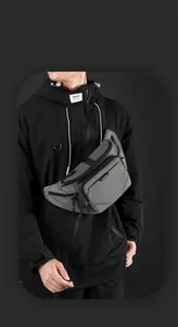 Close-up of waterproof grey crossbody bag with multiple zippers and technical fabric