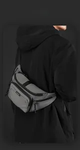 Detail of grey waterproof nylon waist bag with multiple zippers shown on a model
