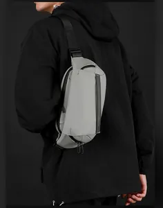 Marsupio grigio minimalista su modello con tessuto opaco e cinturino nero lungo