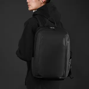Waterproof business backpack in matte black finish, worn by a model for travel use