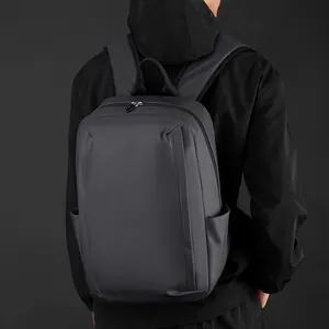 Waterproof charcoal grey minimalist business laptop backpack shown on a male model