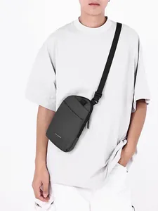 Men's minimalist black waterproof crossbody bag shown on a model in a white t-shirt