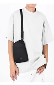 Detail of minimalist black crossbody chest bag featuring a matte waterproof fabric finish