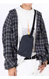 Detail of grey men's crossbody chest bag with adjustable strap and front compartment
