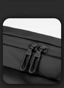 Dettaglio cerniera impermeabile e cursore con logo opaco su borsa a tracolla nera sportiva
